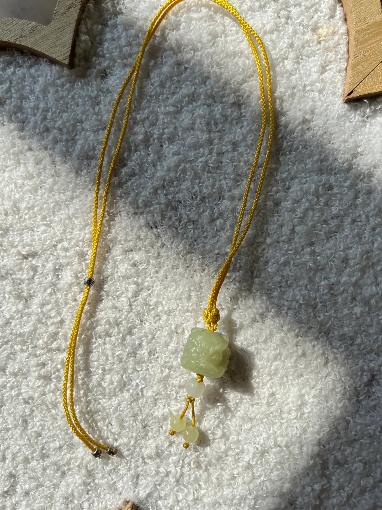 Guardian's Fortune – Hand-Carved Hetian Jade Lion Dance Charm - flat lay display by L'Orient Haus