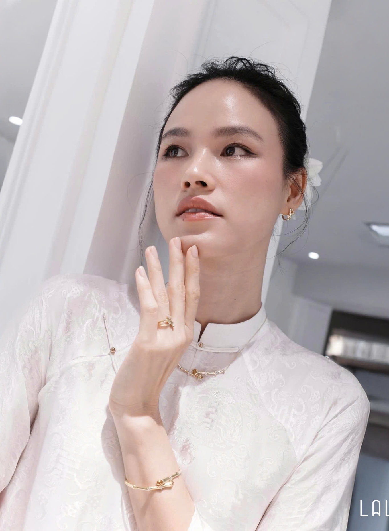 "Hy Loan Ao Dai Set in white silk by Lalin, traditional Vietnamese dress with modern patterns."