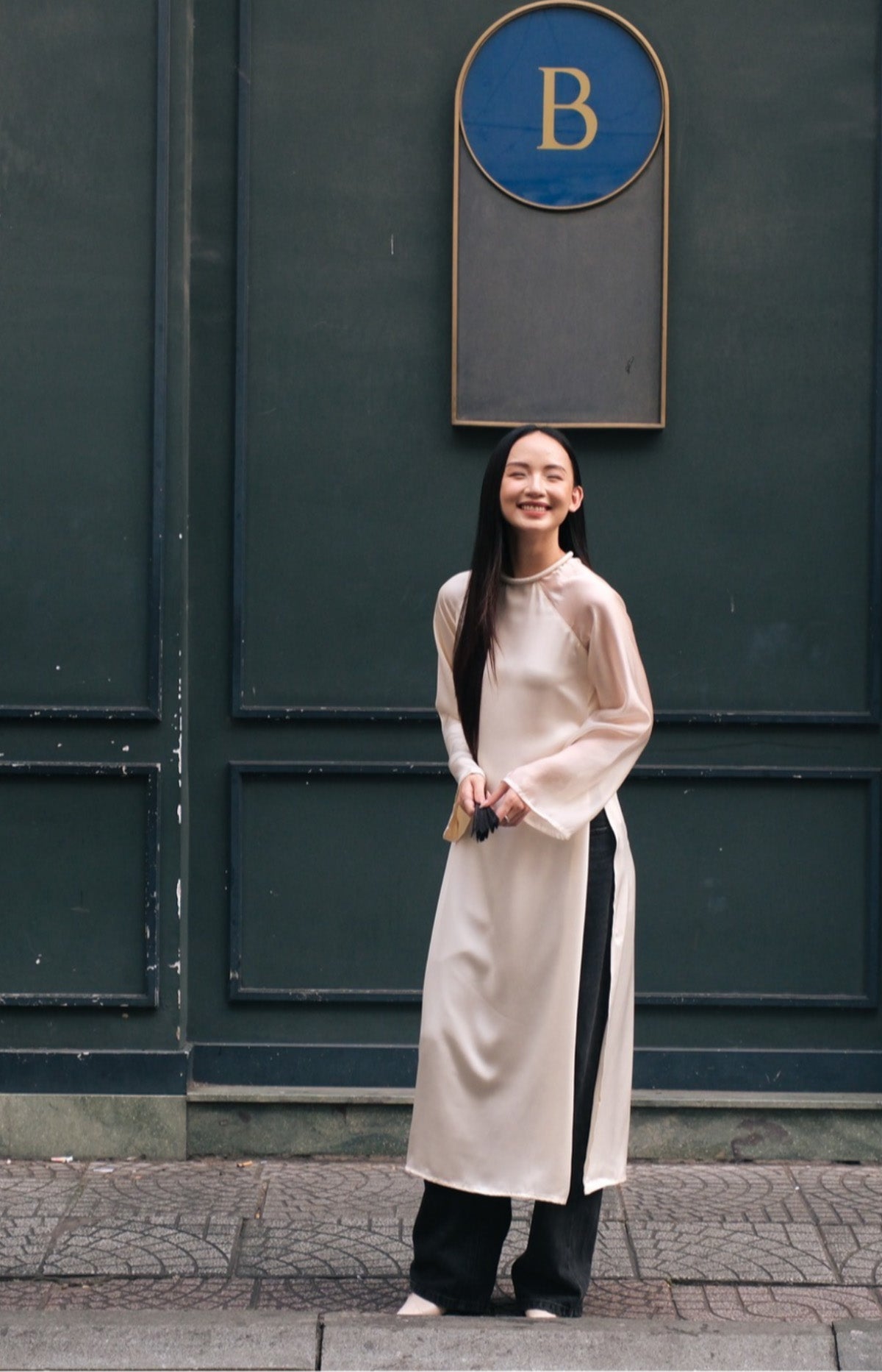 "Traditional Vietnamese Ao Dai 'Tinh Hop' in ivory silk and organza by UoM, modern design."