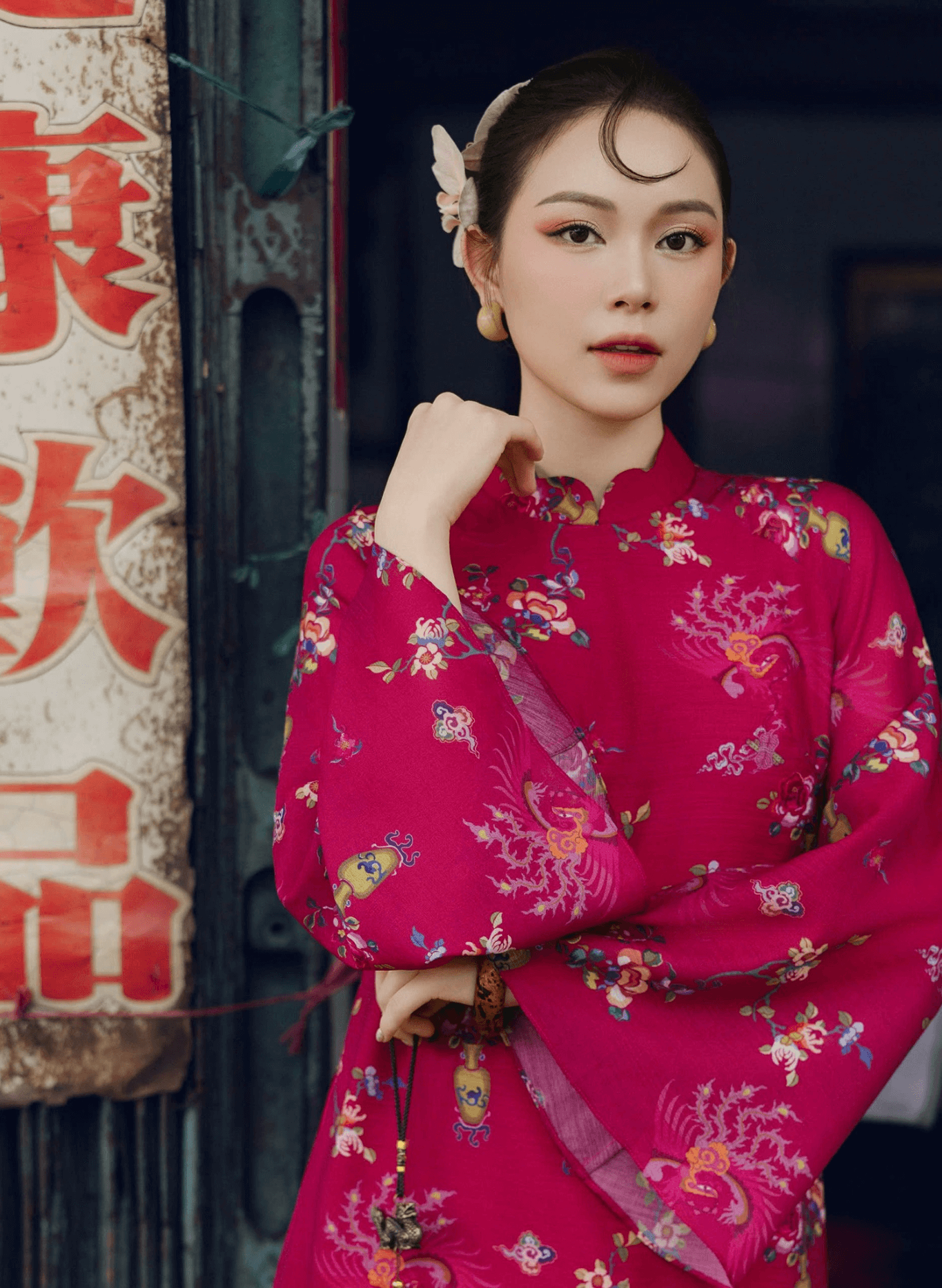 "Giang Chi Ao dai in magenta silk by Lalin, traditional Vietnamese dress with floral pattern."