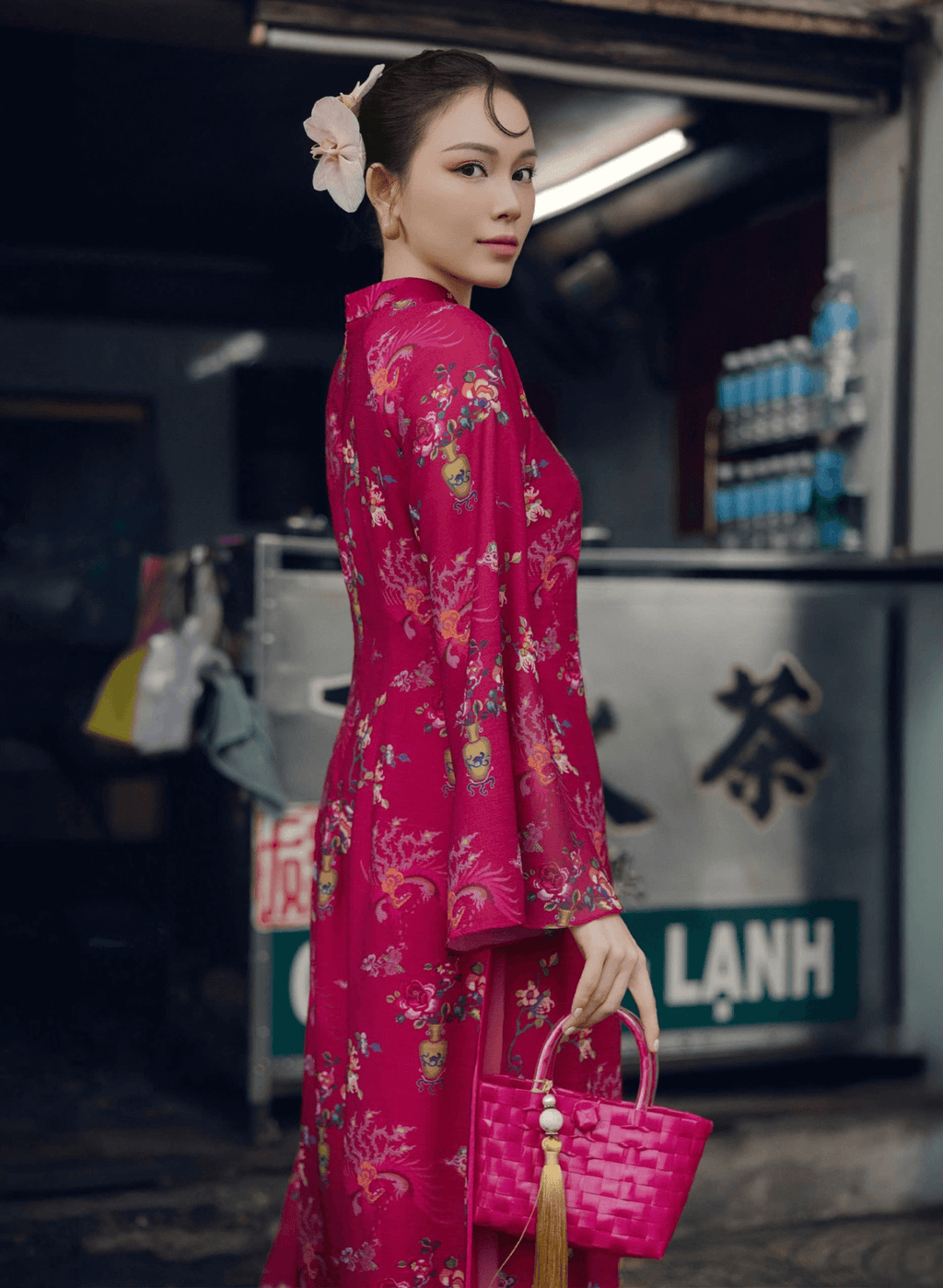 "Giang Chi Ao dai in magenta silk by Lalin, featuring floral patterns, traditional Vietnamese dress."