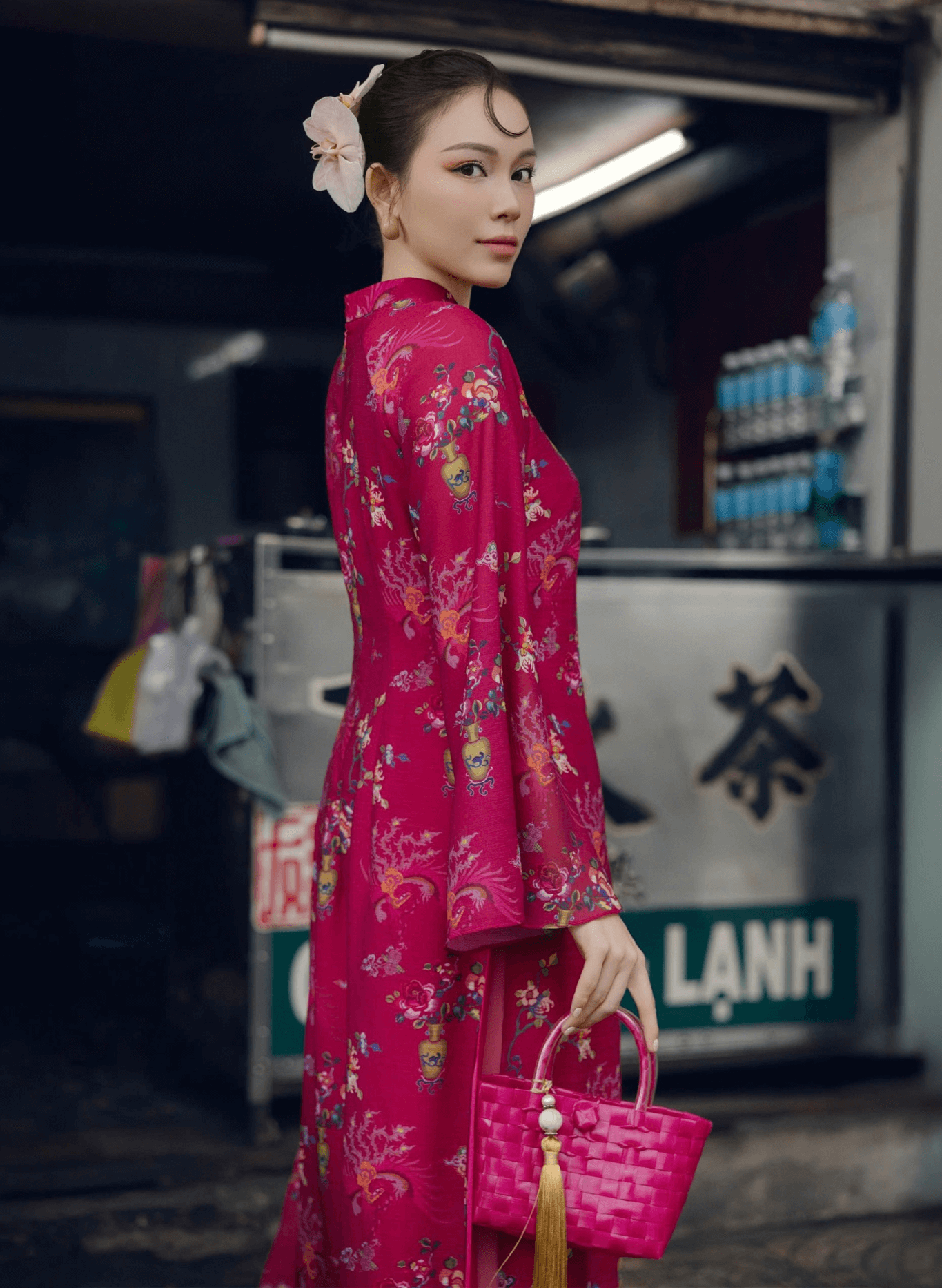 "Giang Chi Ao dai in magenta silk by Lalin, featuring floral patterns, traditional Vietnamese dress."