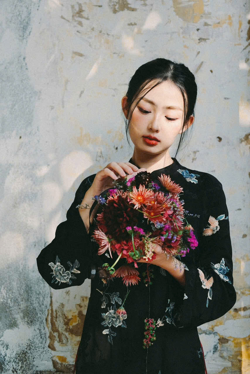 "Traditional Vietnamese Ao dai in black silk with floral embroidery, cultural elegance"