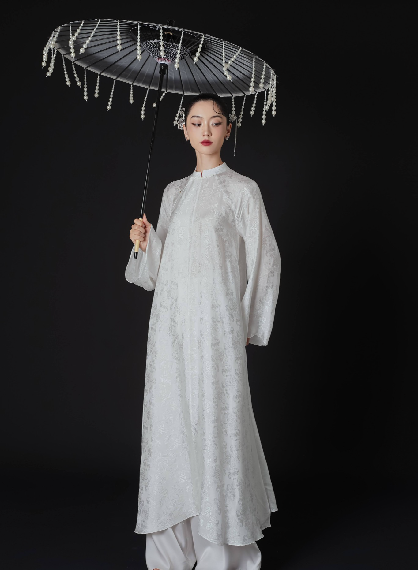 "Hy Loan Ao Dai Set in white silk by Lalin, traditional Vietnamese dress with modern design."
