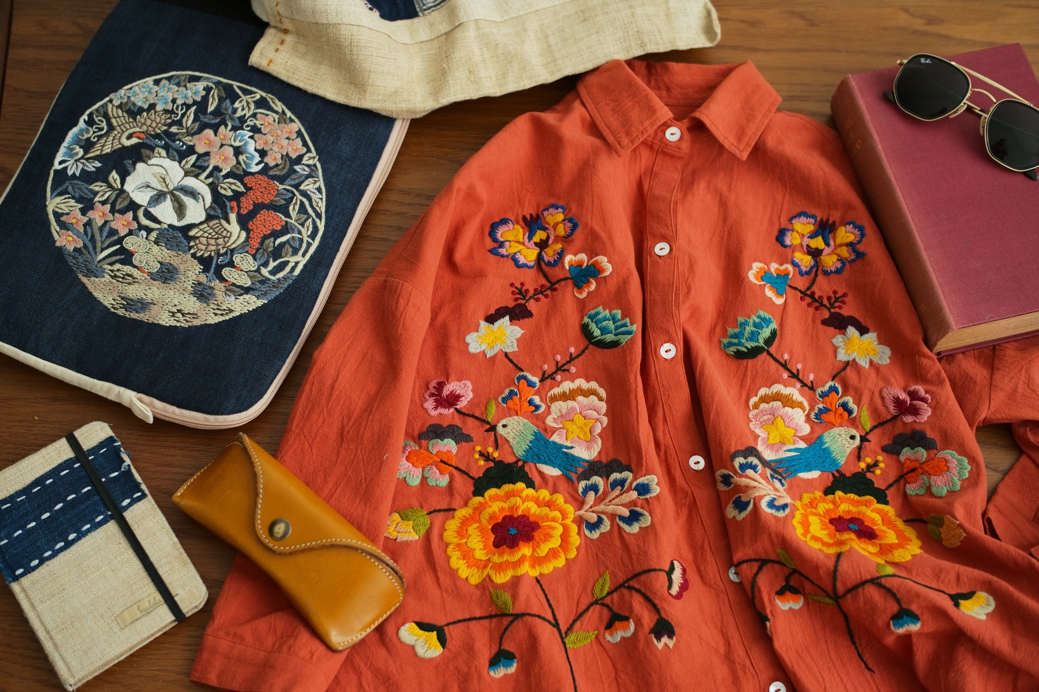 "Huulala 'Sophie' embroidered linen shirt in orange with vibrant floral patterns, showcasing Vietnamese cultural authenticity."