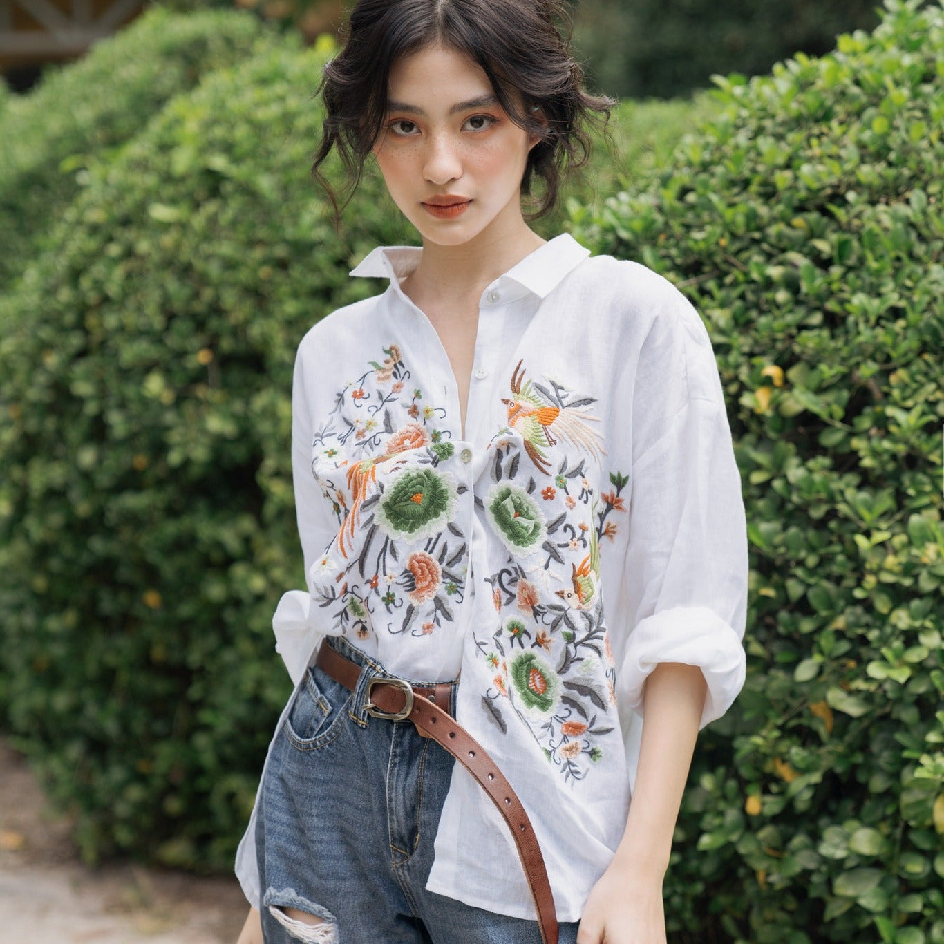 "Zoya embroidered linen shirt by Huulala in white with pink floral design, Vietnamese-inspired fashion."