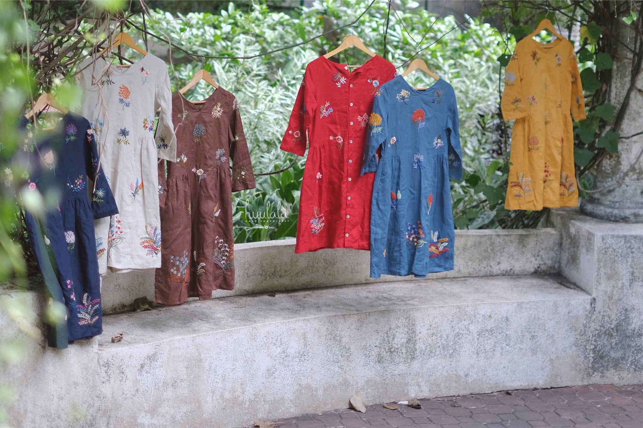 "Vietnamese embroidered linen dress in yellow by Huulala, featuring floral patterns and cultural authenticity."