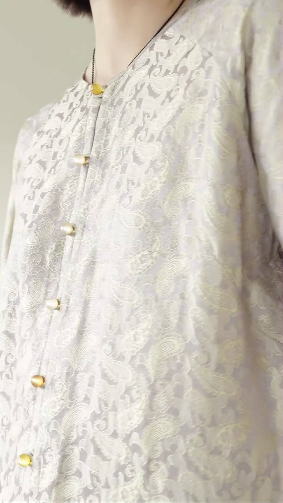 Traditional Vietnamese Ao Ba Ba "An" in jacquard silk, close-up of fabric texture and craftsmanship