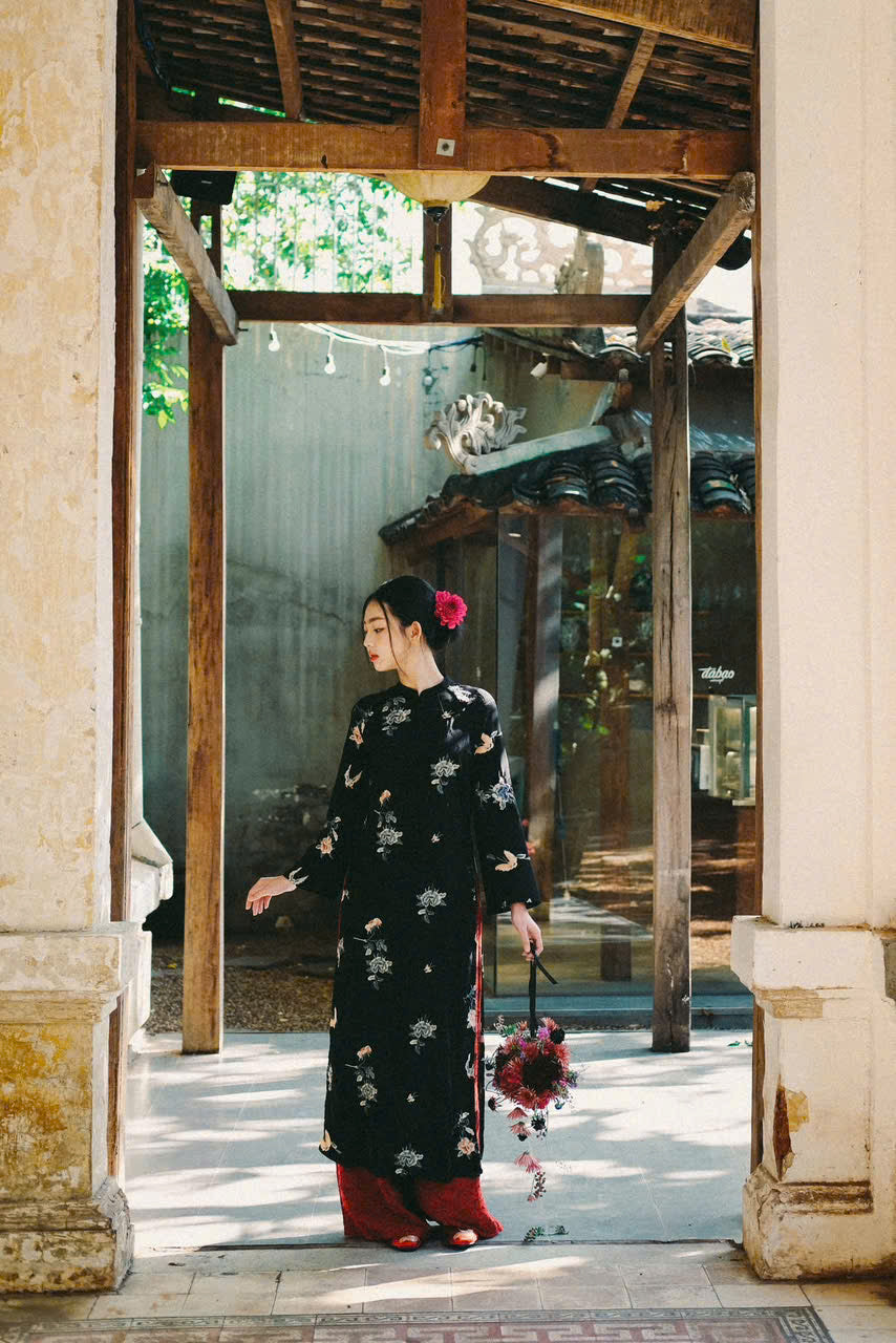 "Traditional Vietnamese Ao dai set in black silk with floral embroidery, featuring artisan craftsmanship."