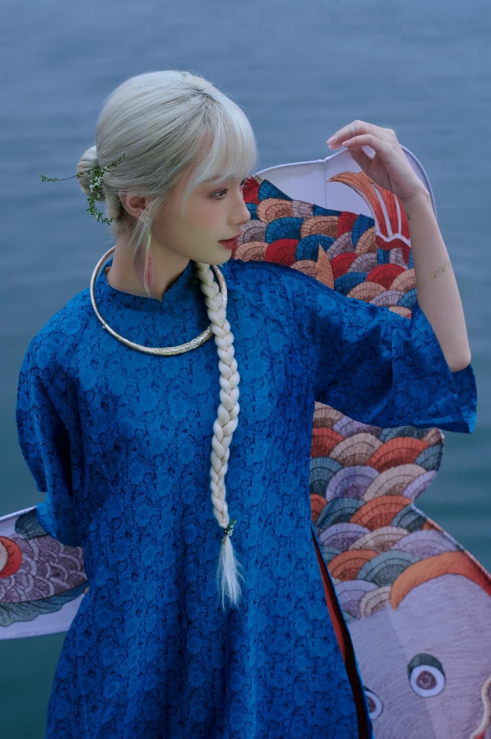 "Elegant 'Cuc Hoa' Ao Dai set in sapphire silk with traditional Vietnamese jacquard pattern."