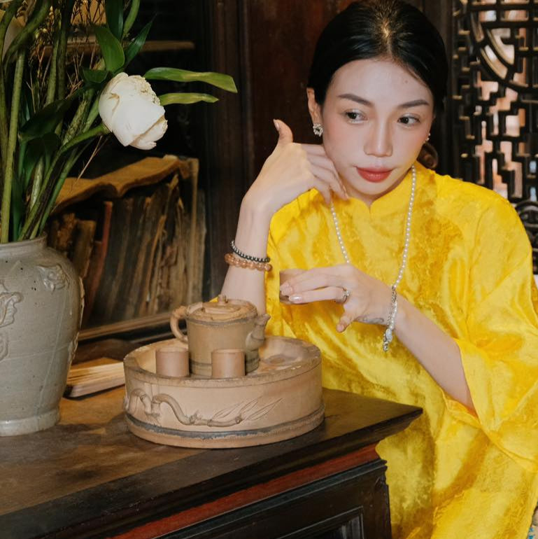 "Traditional Vietnamese Ao dai in yellow silk jacquard, artisan-crafted by Moc, with cultural authenticity."