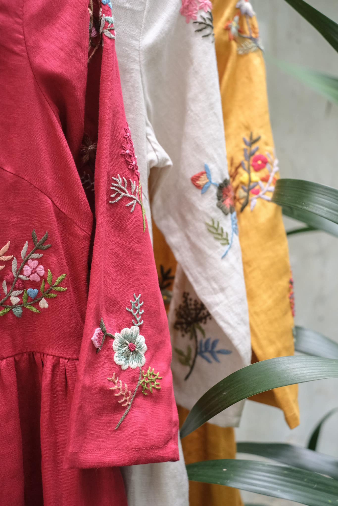 "Vietnamese embroidered linen dresses in red, white, and yellow with floral patterns by Huulala."