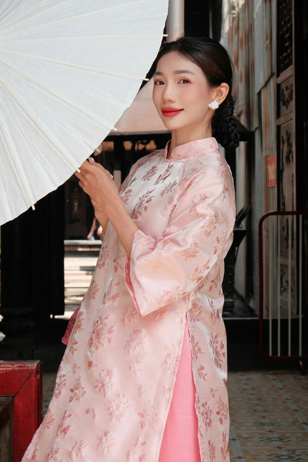 "Giang Dinh Huong Ao Dai set in light pink silk with jacquard floral pattern, traditional Vietnamese dress."