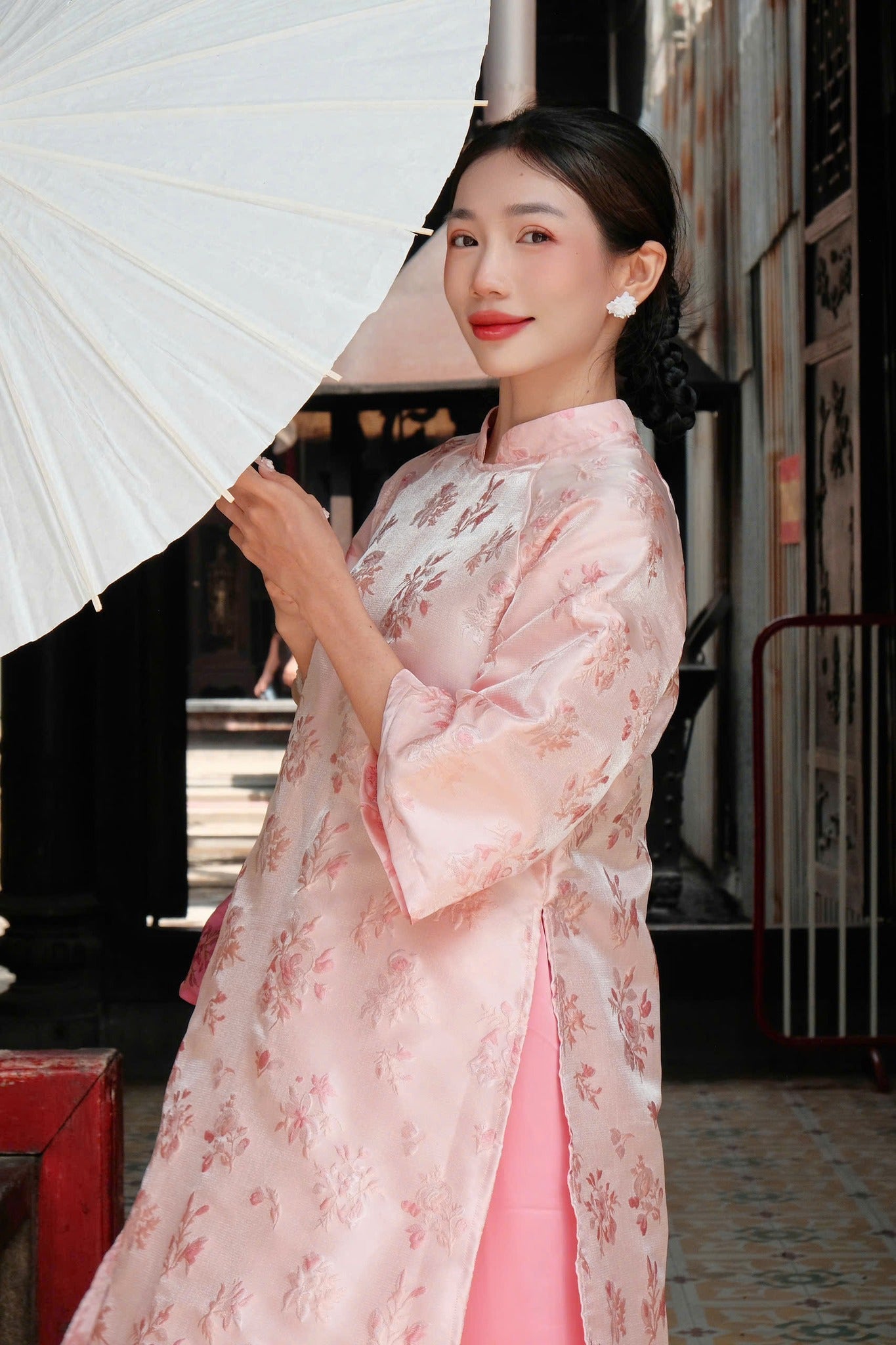"Giang Dinh Huong Ao Dai set in light pink silk with jacquard floral pattern, traditional Vietnamese dress."