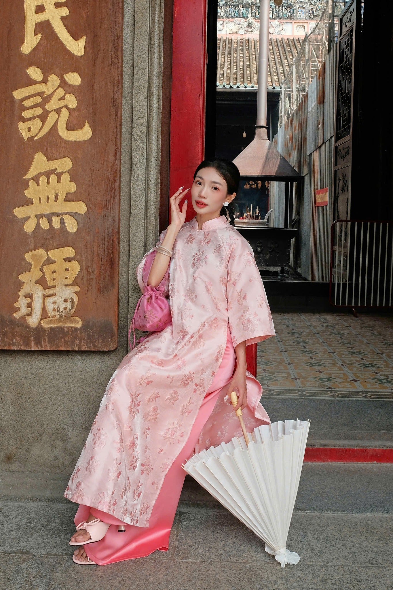"Giang Dinh Huong Ao Dai set in light pink silk with jacquard floral pattern, traditional Vietnamese dress."