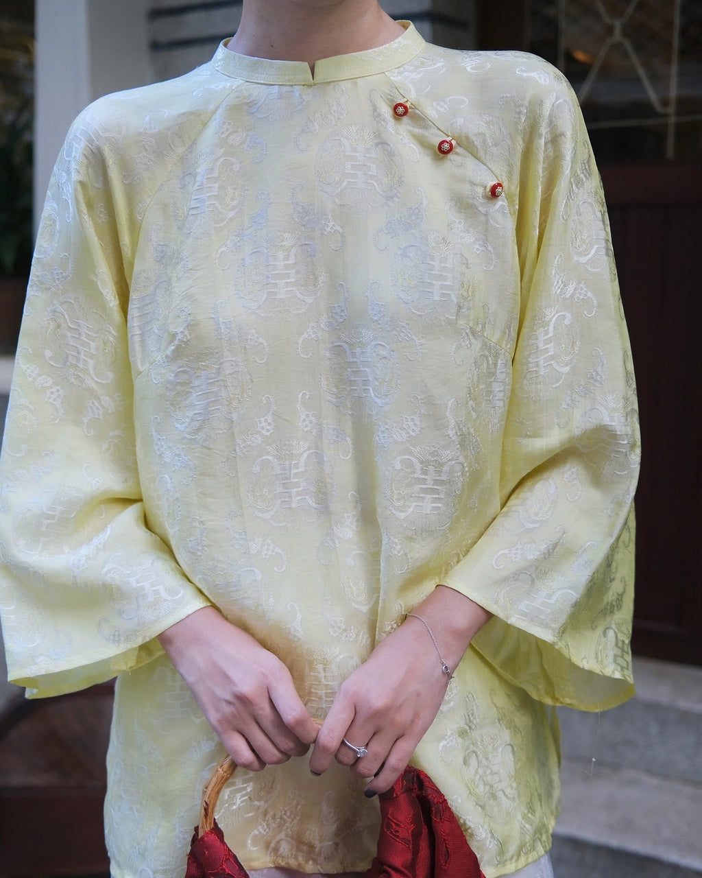 "Tra My Mandarin-neck top in light yellow woven silk, modern pattern, cultural authenticity"