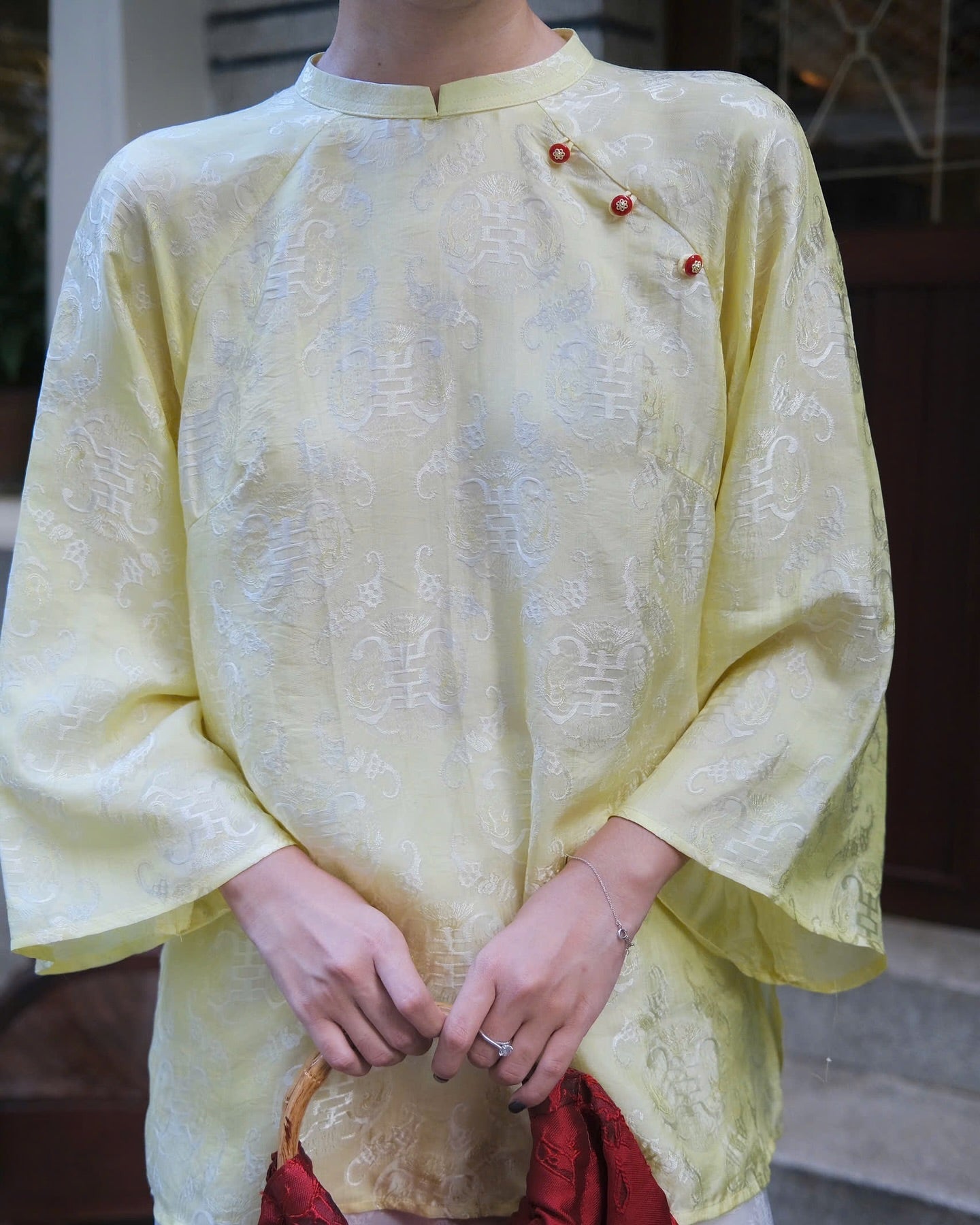 "Tra My Mandarin-neck top in light yellow woven silk, modern pattern, cultural authenticity"