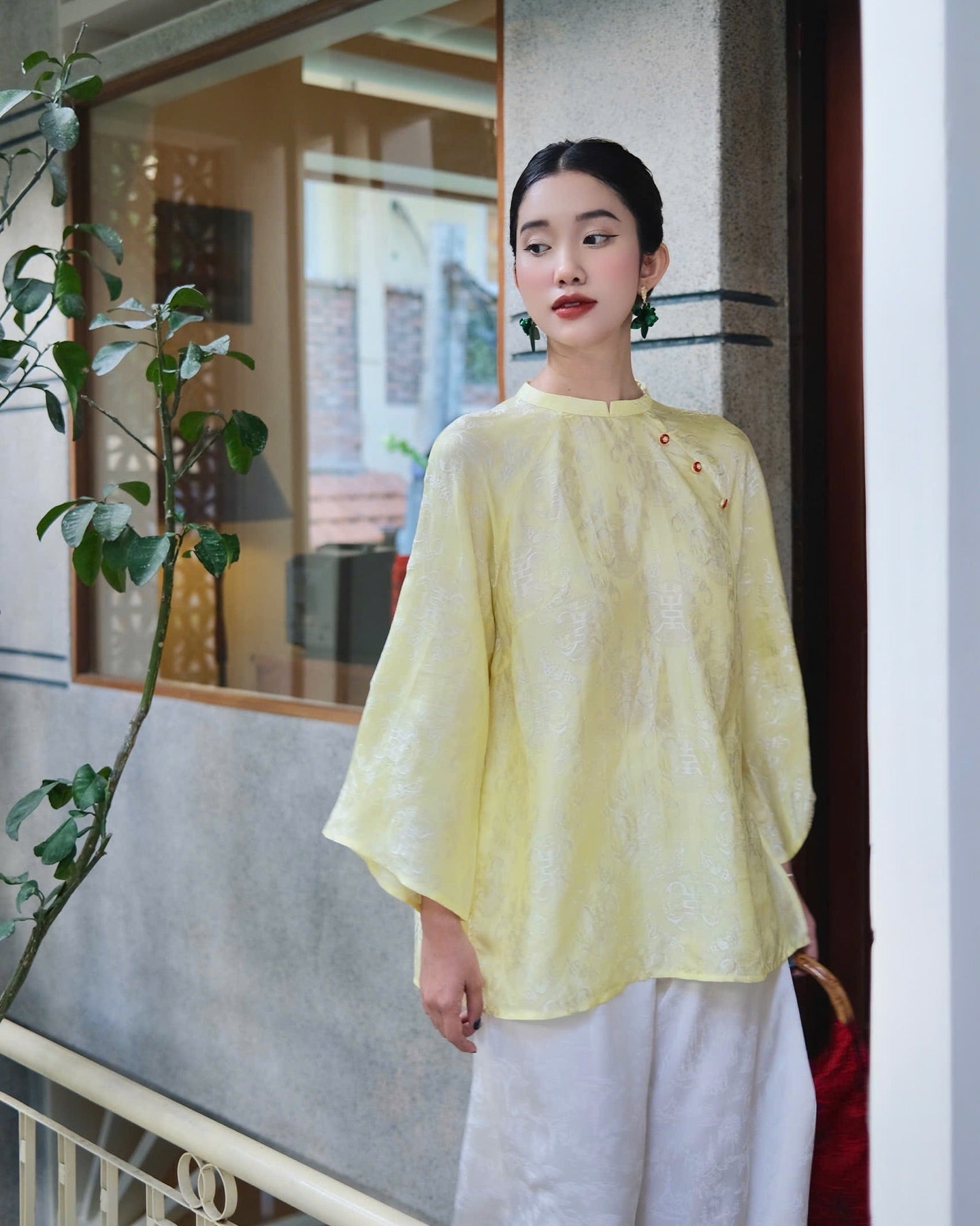 "Tra My Mandarin-neck top in light yellow woven silk, modern pattern, cultural Vietnamese design"
