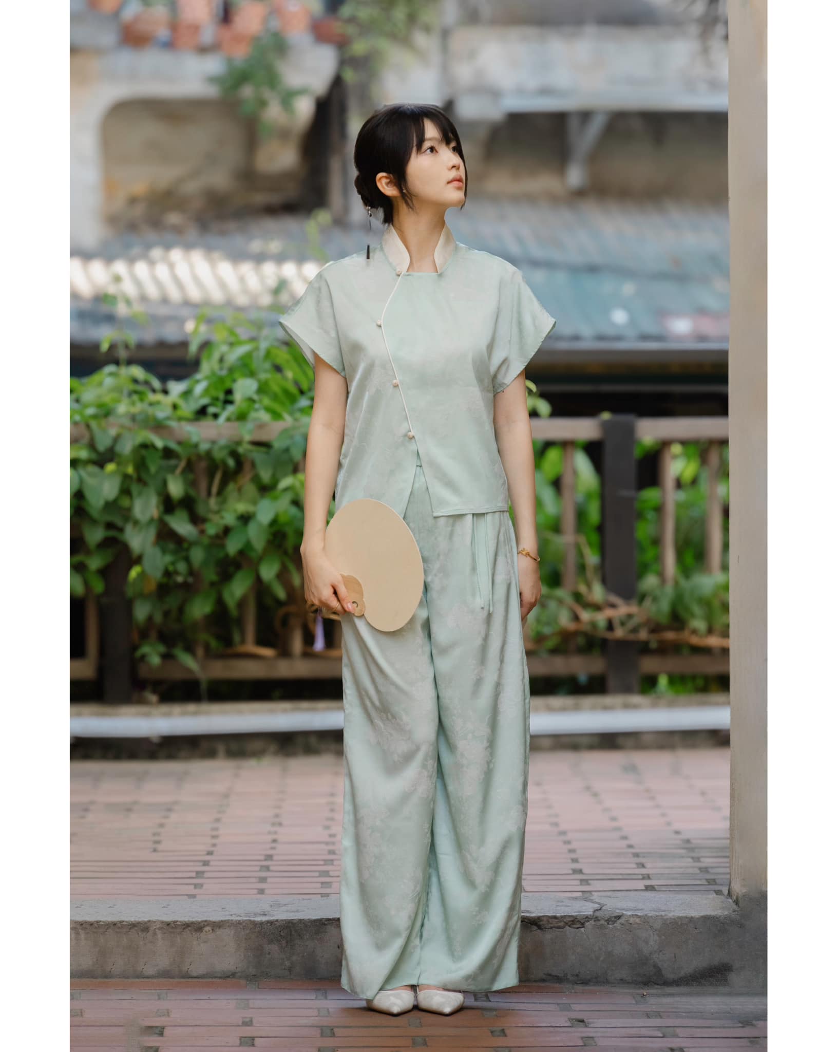 "Mint green 'Nghinh Xuân' top by Hy Phuong, featuring a Mandarin neck and modern jacquard patterns, Vietnamese style."