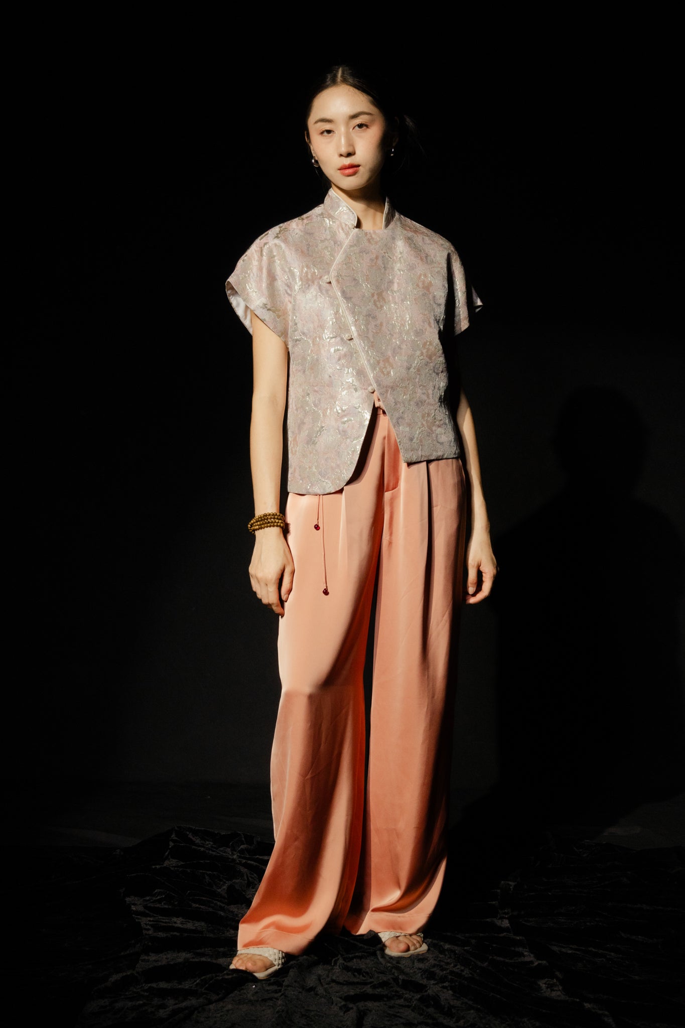 "Traditional Vietnamese Nghinh Xuan set with pleated peach orange silk pants and tassel, by Hy Phuong."