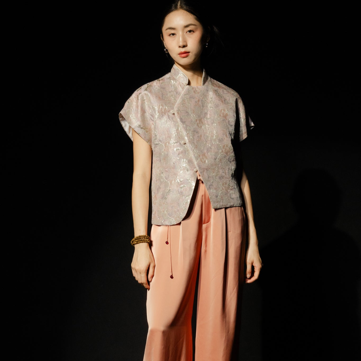 Vietnamese Embroidery - Nghinh Xuan Set - Pleated Silk Pants in Peach Orange with Tassel - front view in pink by Hy Phuong