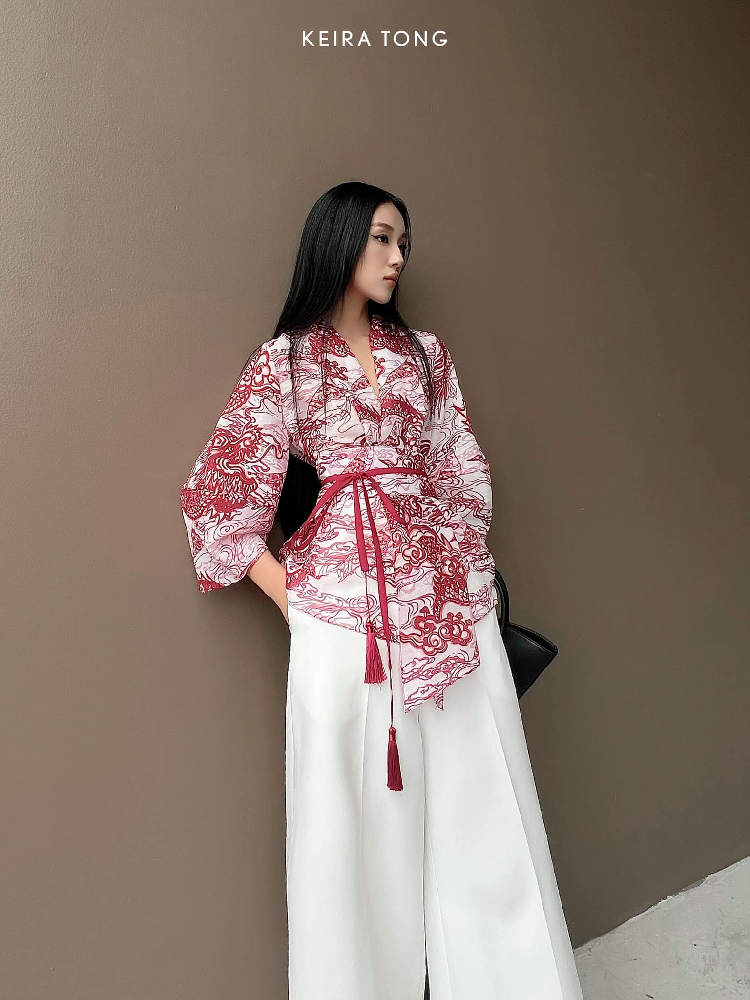 "Vĩ Kimono Top by Keira Tong in black silk organza with red traditional patterns, blending modern and cultural elegance."