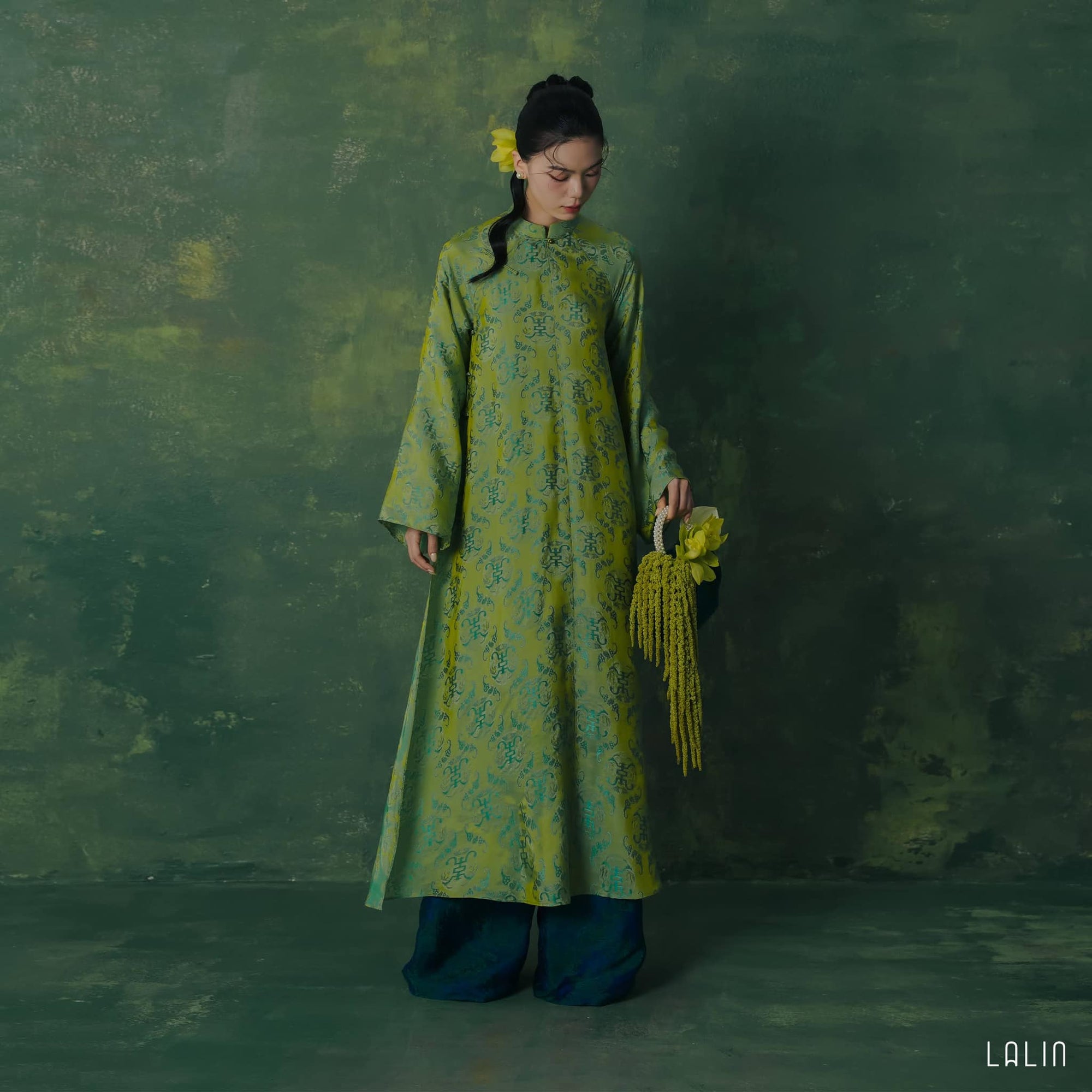 "Diep Thanh Ao Dai set in jade green silk by Lalin, traditional Vietnamese dress with modern woven patterns."