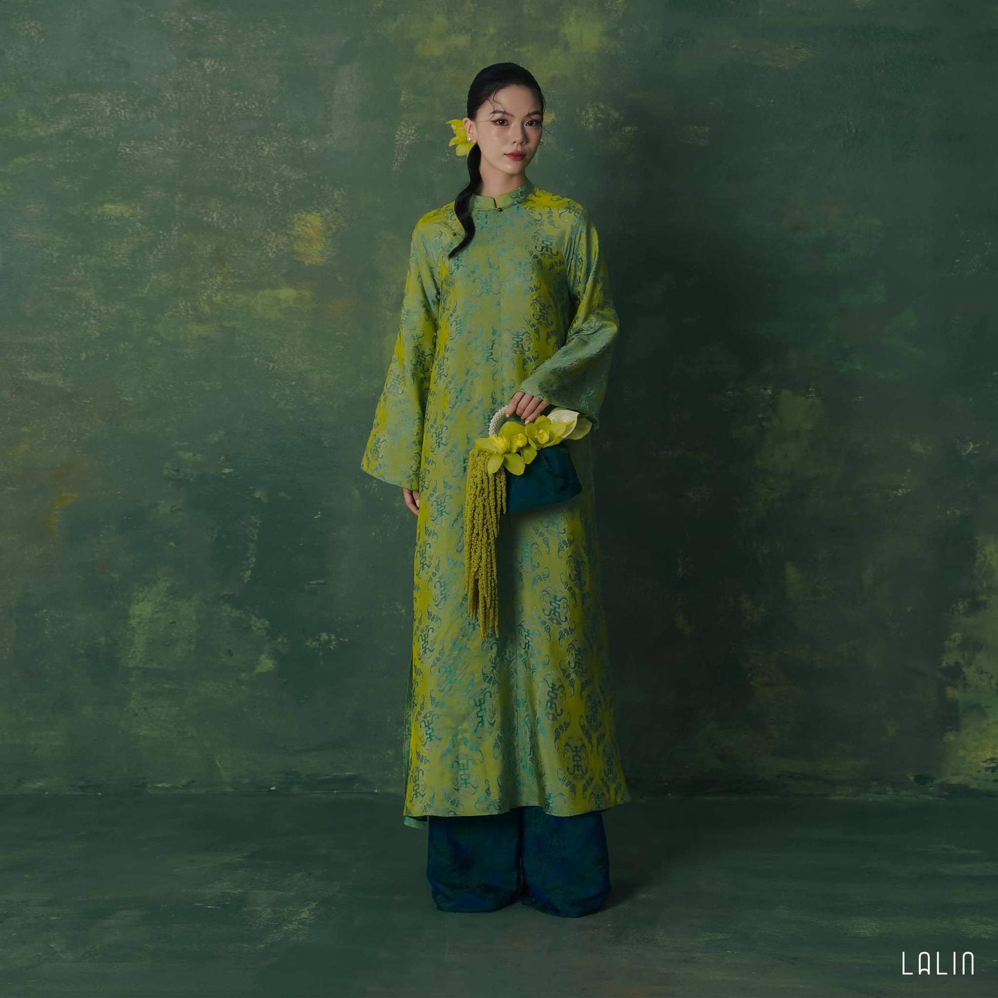 "Diep Thanh Ao Dai set in jade green silk by Lalin, traditional Vietnamese dress with artisan woven patterns."