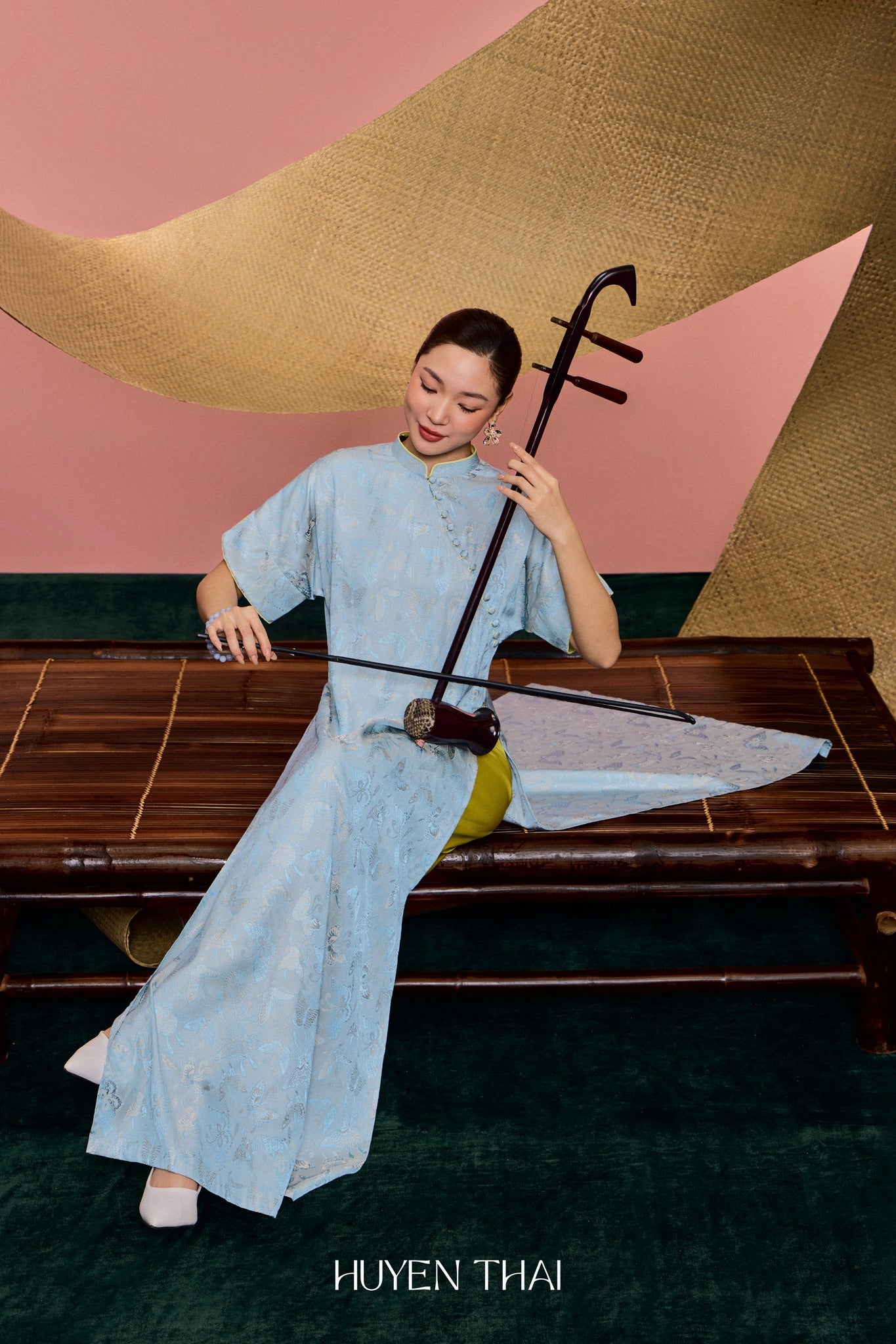 "Traditional Vietnamese Ao Dai in blue silk jacquard with avocado lining, modern design by Huyen Collection."