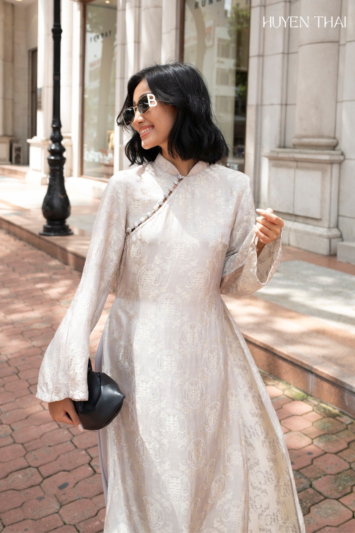 "Elegant ivory grey Ao Dai set by Huyen Collection, featuring artisan silk jacquard with modern patterns, embodying Vietnamese cultural authenticity."