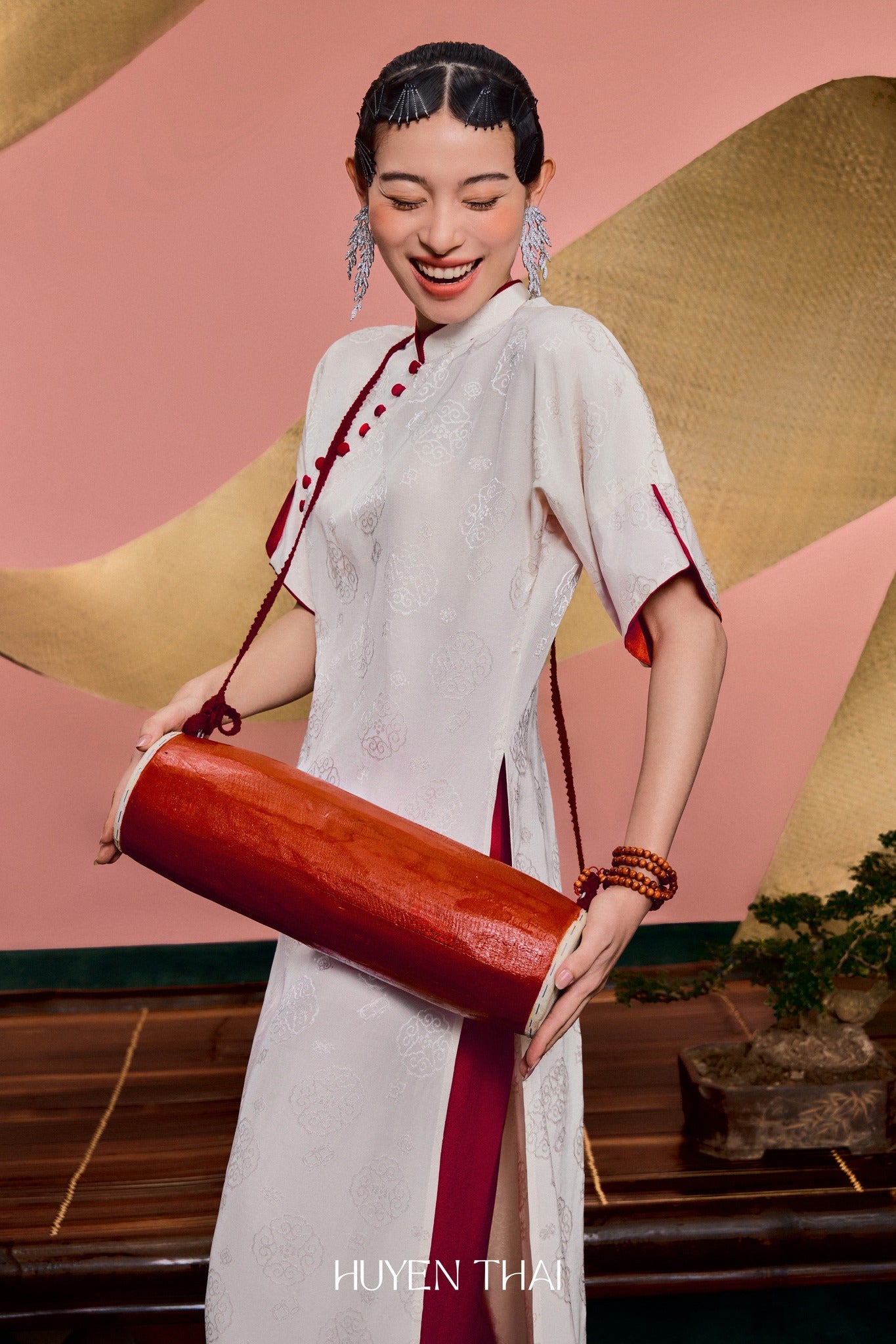 "Van Nha Ao Dai in ivory silk with crimson lining, traditional Vietnamese dress by Huyen Collection."