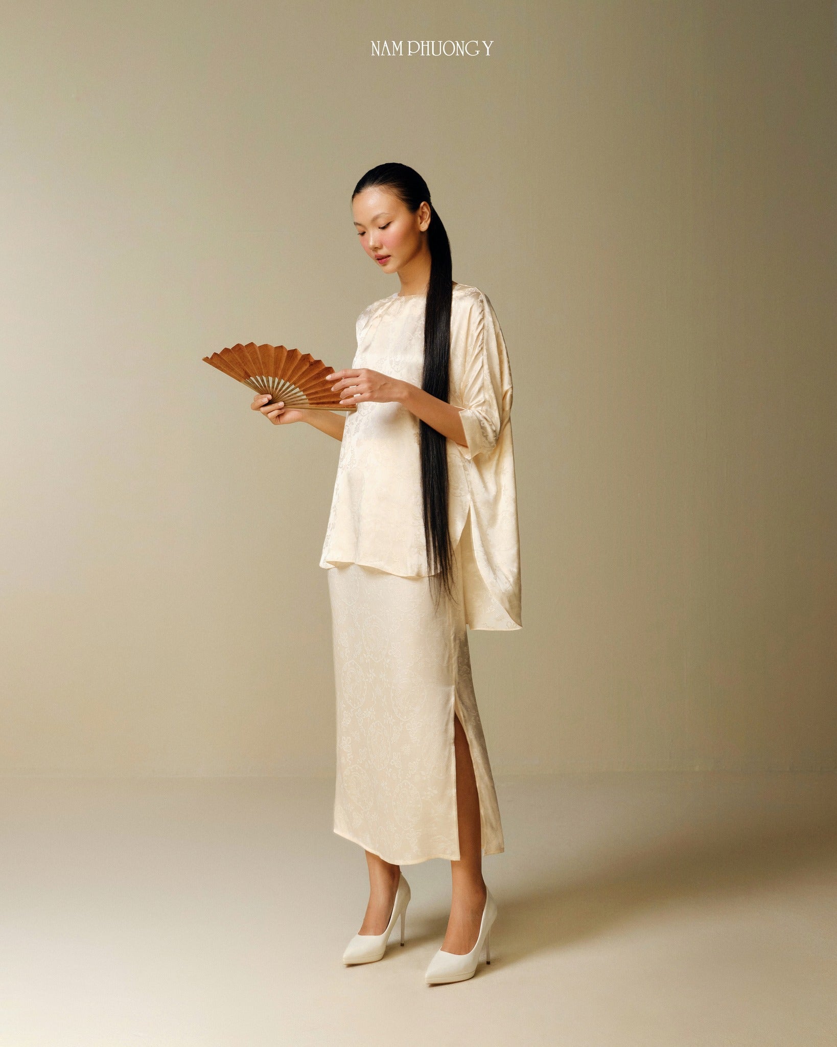 "Traditional Vietnamese dress 'Dong' in light yellow jacquard silk by Nam Phuong Y"