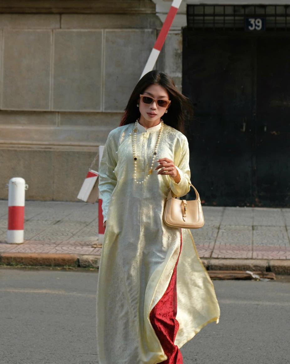 "Traditional Vietnamese Ao Dai set in cream silk with red pants, chrysanthemum pattern, artisan design."