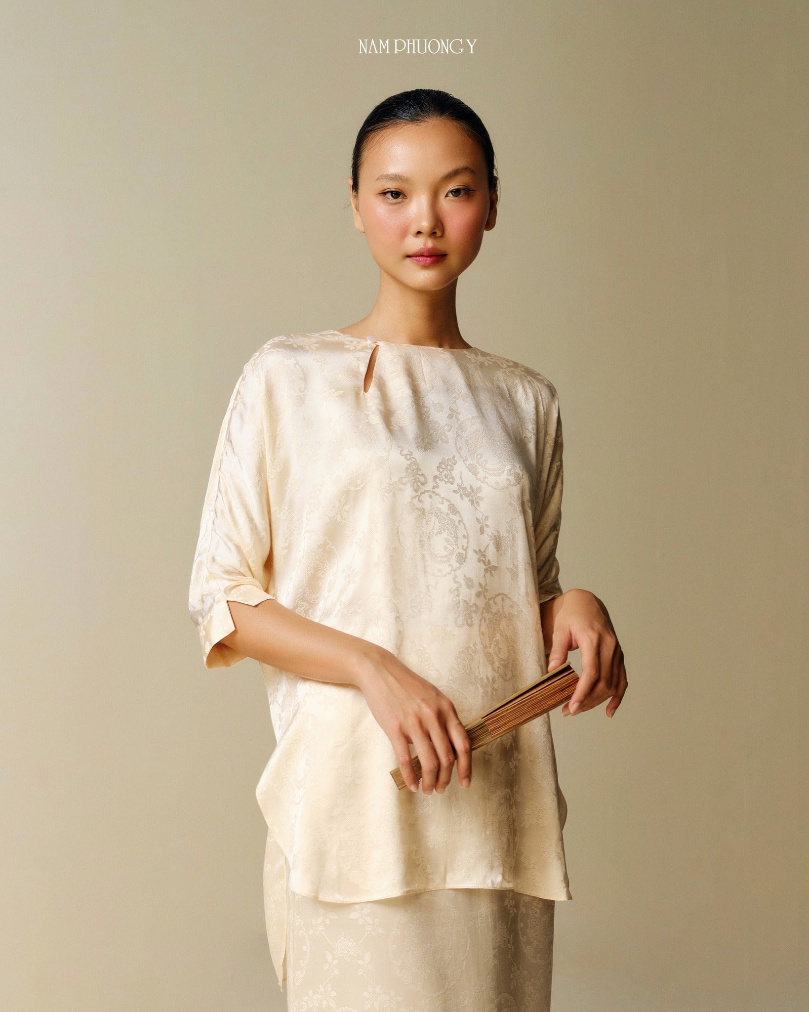 "Traditional Vietnamese dress 'Dong' in light yellow jacquard silk by Nam Phuong Y"