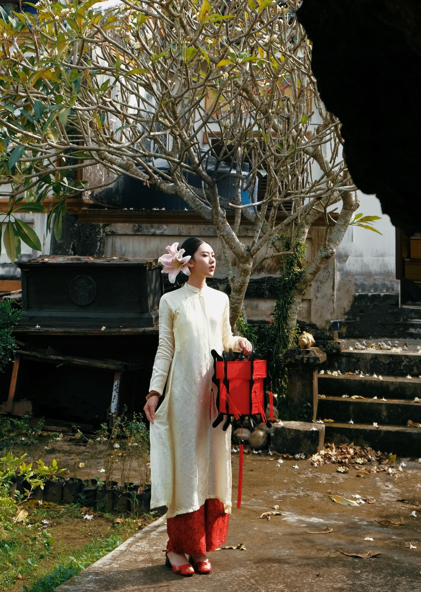 "Traditional Vietnamese Ao Dai set in cream silk with chrysanthemum pattern, featuring red woven pants, embodying cultural authenticity."
