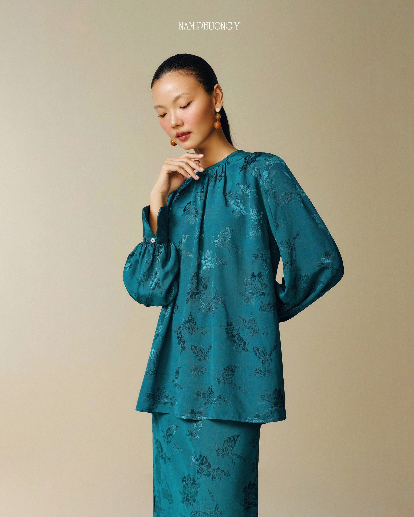 "Traditional Vietnamese dress 'Dong' in dark teal jacquard silk with modern floral pattern by Nam Phuong Y"