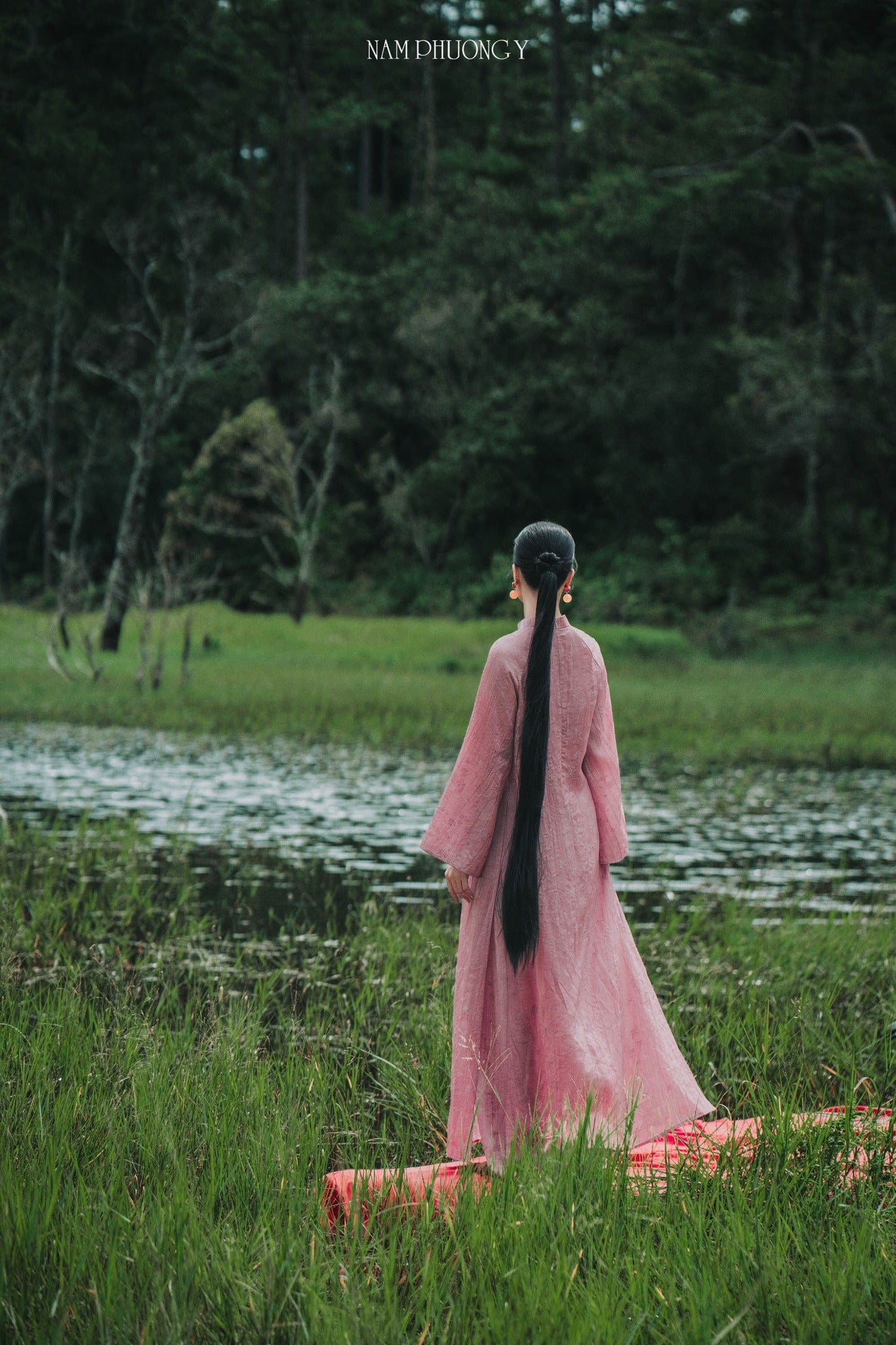 "Premium Natural Silk Ao dai Set in Pink by Nam Phuong Y, traditional Vietnamese dress in serene landscape"