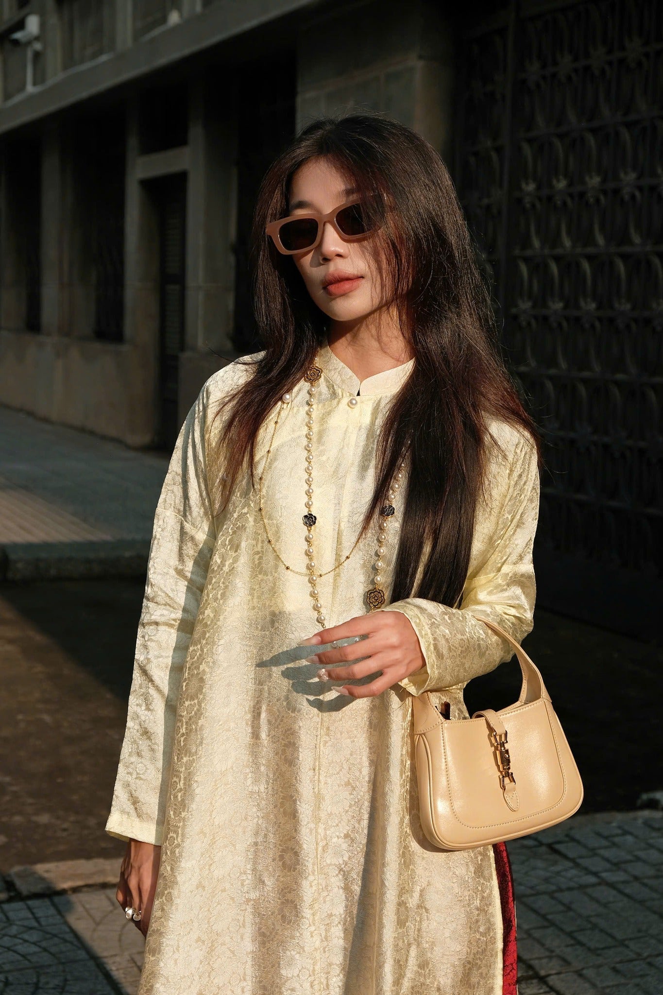 "Traditional Vietnamese Ao Dai in cream silk with chrysanthemum pattern, artisan-crafted by Moc."