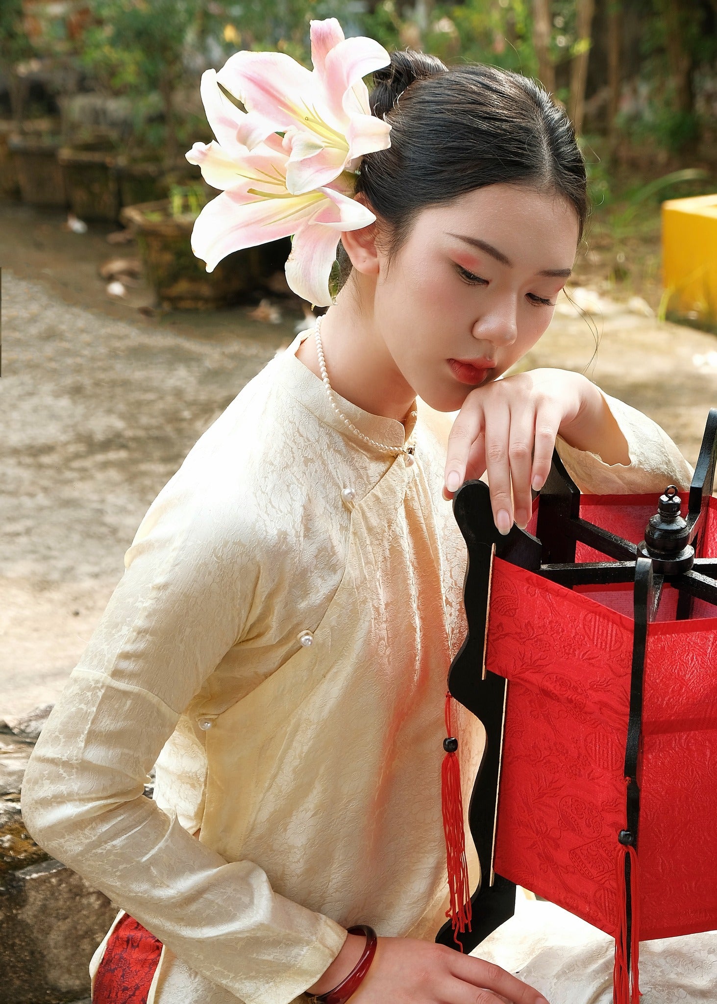 "Traditional Vietnamese Ao Dai set in cream silk with chrysanthemum pattern, featuring red accents, by Moc."