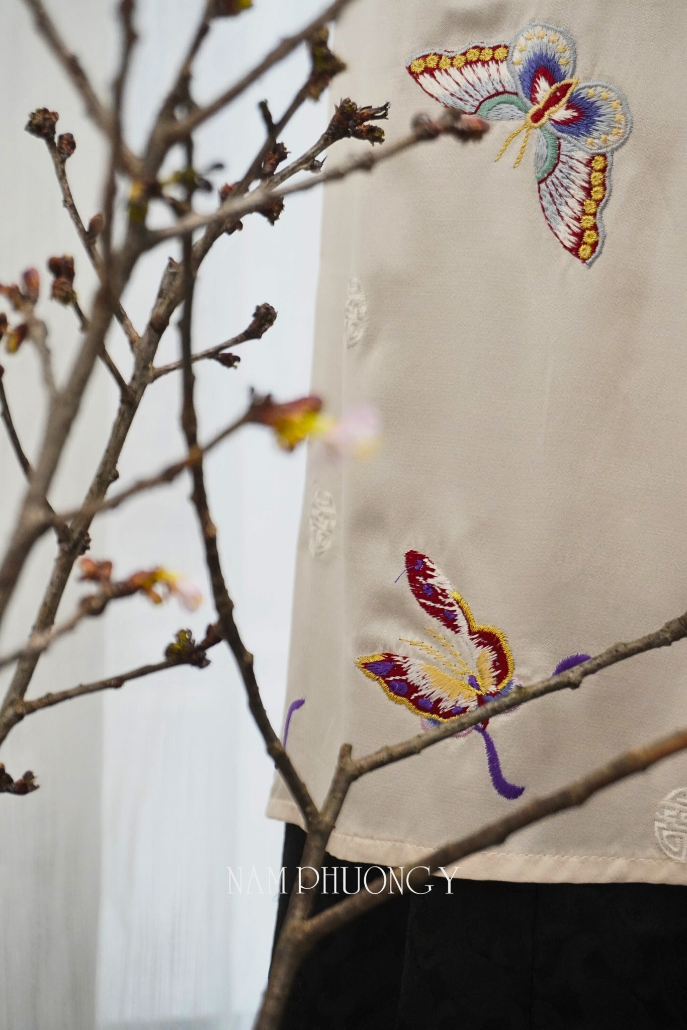 "Tú Điệp" premium ivory silk Ao Dai with colorful butterfly embroidery, traditional Vietnamese dress.
