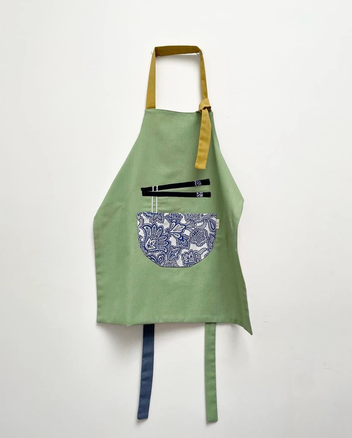 "Phở Apron – Handmade Vietnamese cotton apron with floral pocket, green and yellow accents"
