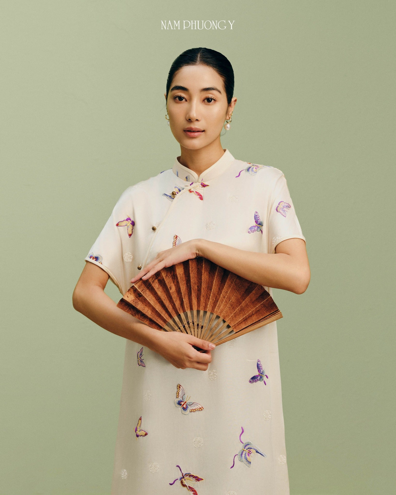 "Premium ivory silk Ao Dai with colorful butterfly embroidery, traditional Vietnamese dress by Nam Phuong Y."