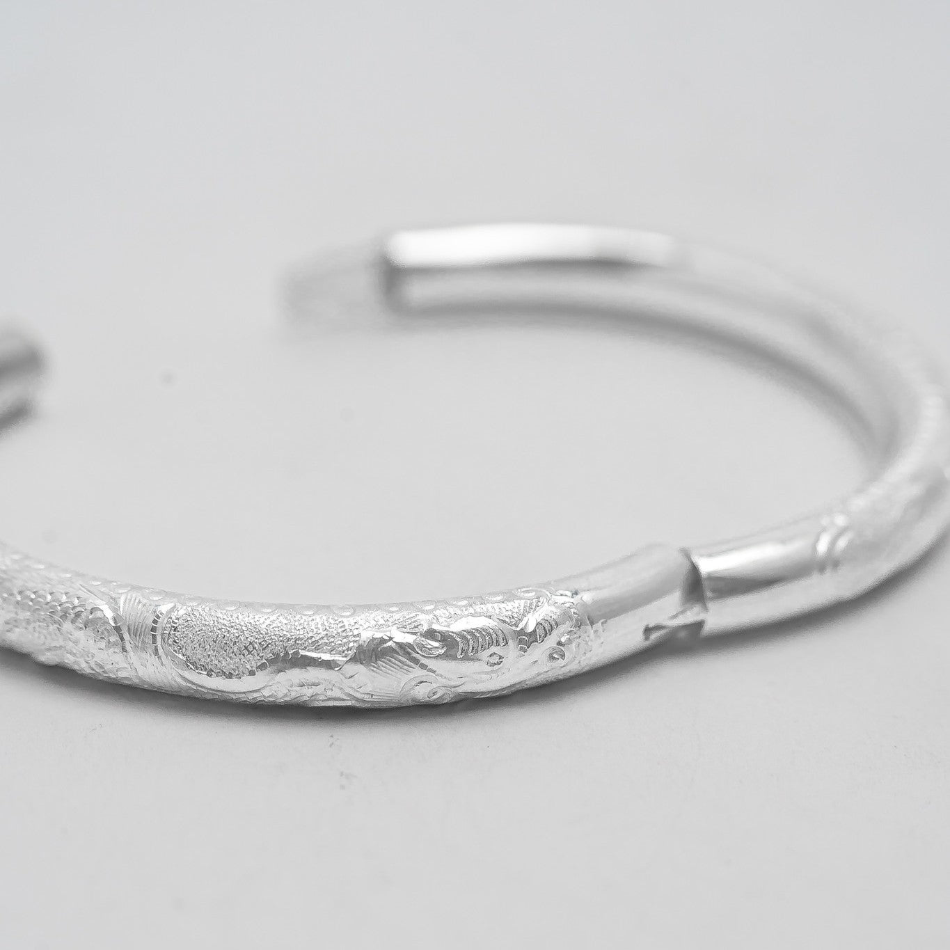 Linh Văn – Hollow Bangle in Lotus or Dragon Pattern - detail close-up in silver by HI de Maison
