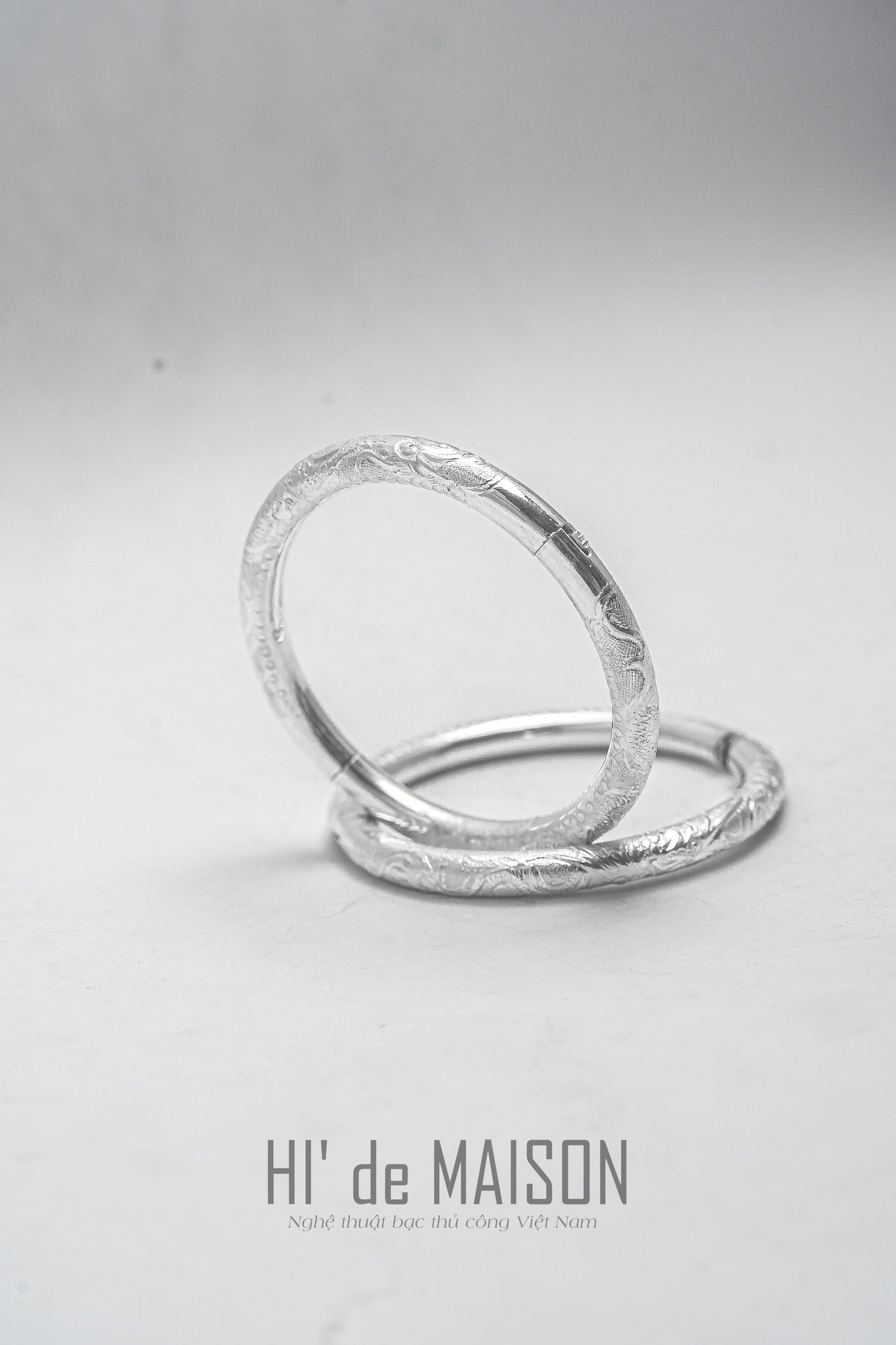 "Linh Văn hollow bangle with lotus or dragon pattern, silver artisan design, cultural authenticity by HI de Maison."