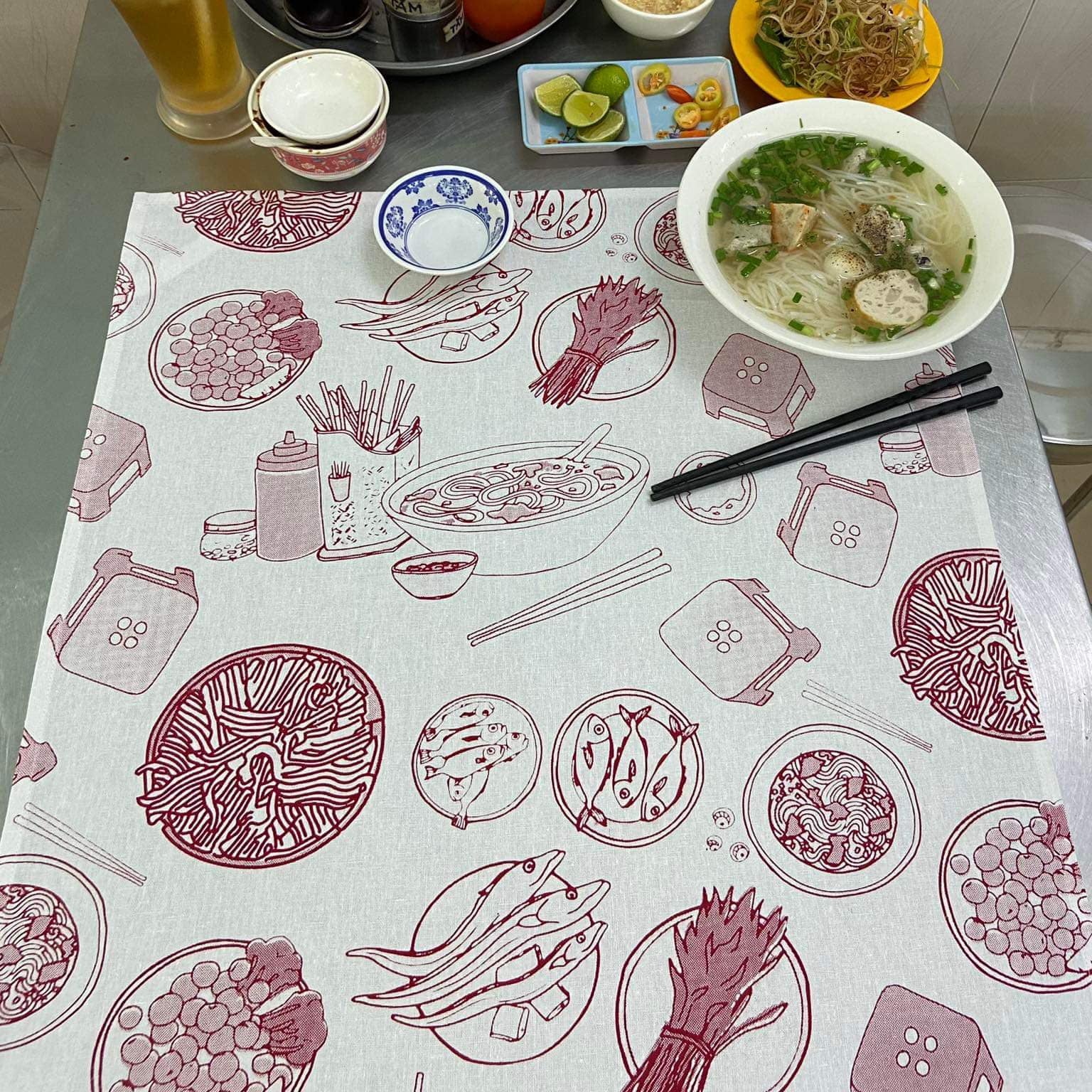 "Vietnam in a Bowl Kitchen Towel by Bat-trang, red illustrations of Vietnamese cuisine on white fabric, cultural authenticity"