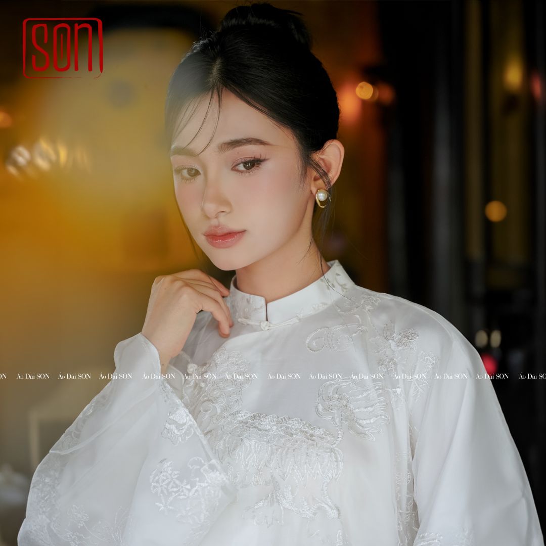 "Uyen Son Embroidered Organza Ao Dai set in white silk with floral patterns, traditional Vietnamese wedding dress."