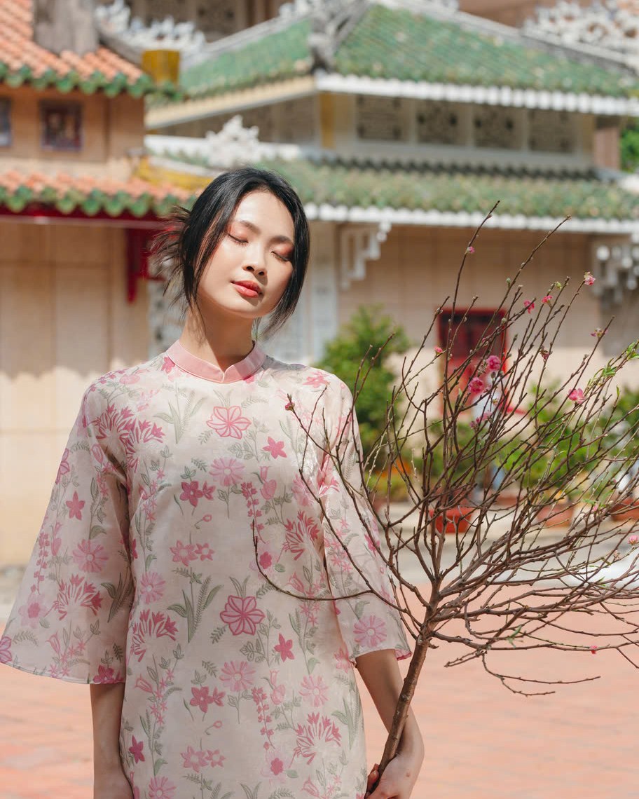 "Thieu Hoa Jacquard Ao Dai Set in pink silk with floral embroidery, traditional Vietnamese dress."