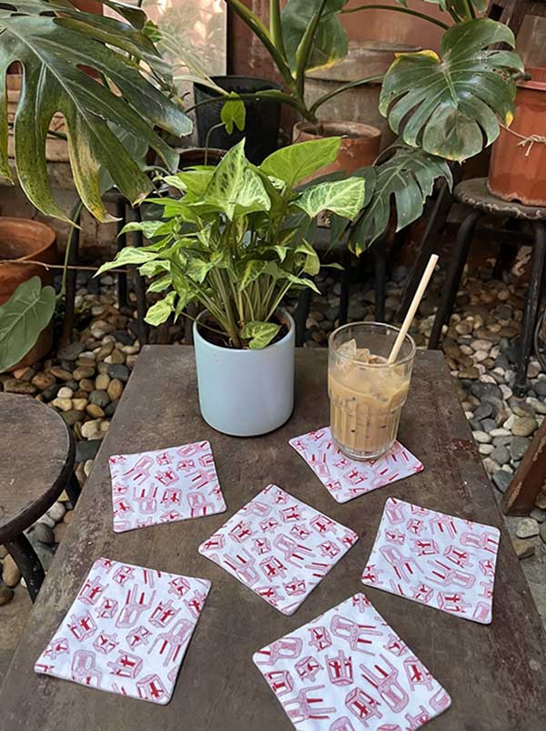"Vietnam in a Bowl" coaster set of 6 by Bat-trang, featuring red Vietnamese patterns on a rustic table.