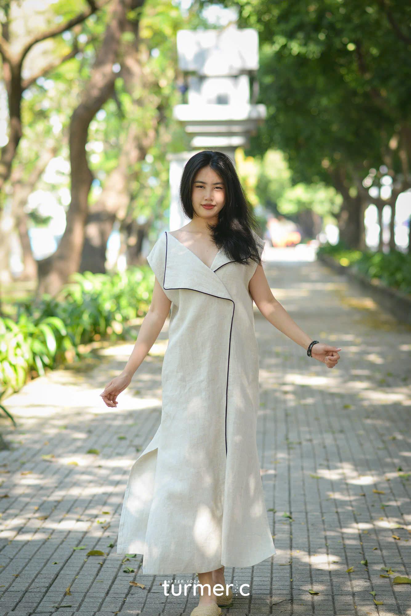 "Rosa linen maxi dress in cream by Turmeric, modern design, sleeveless with black trim, elegant summer wear."