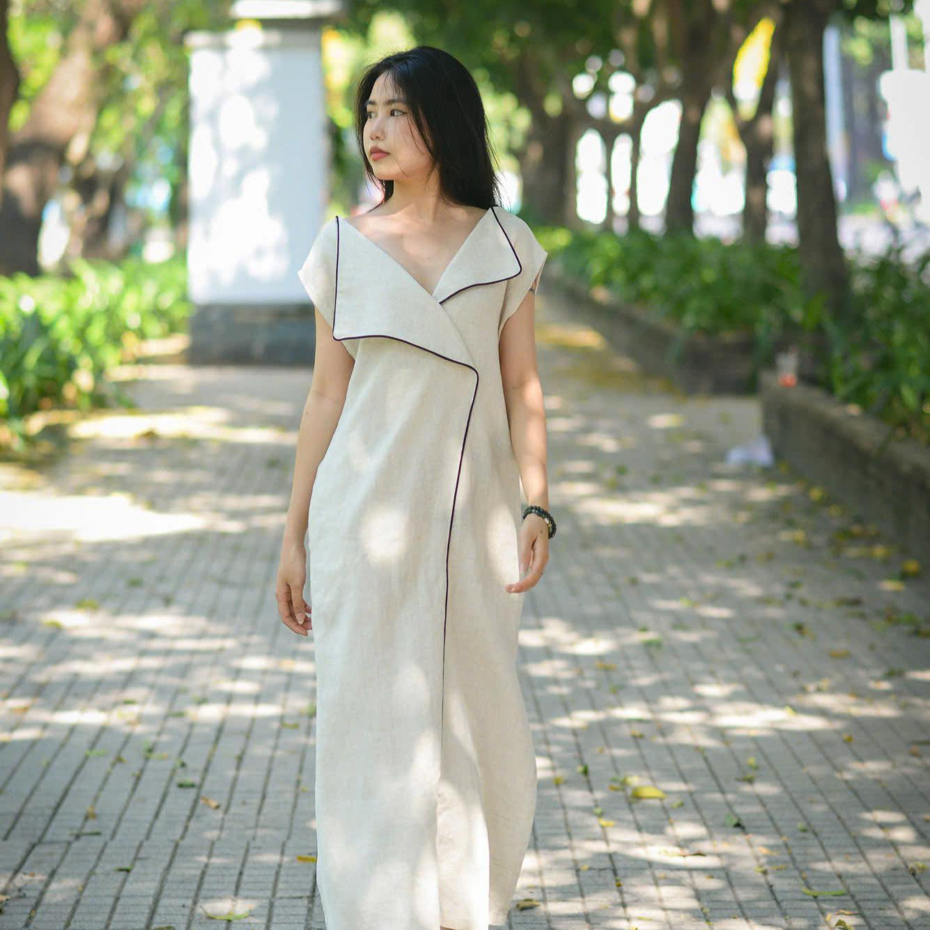 "Rosa linen maxi dress in cream by Turmeric, modern design, sleeveless with black trim accents"